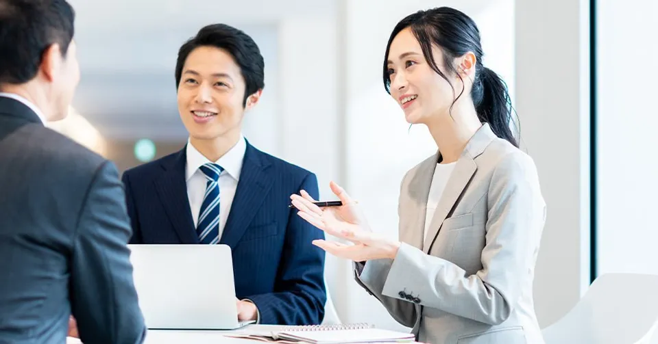 スーツ姿のスタッフが笑顔で相談に対応する様子
