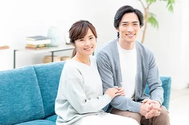 ソファに並んで微笑む夫婦らしき男女